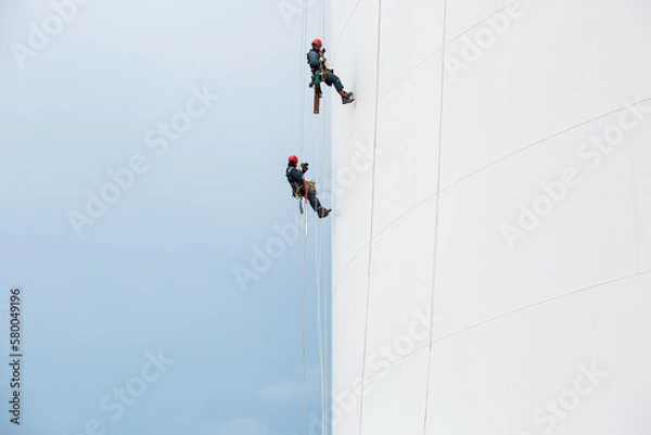 Fototapeta Male two worker down height tank roof rope access safety inspection thickness weld of storage tank