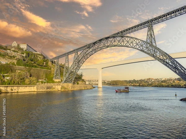 Fototapeta Douro river with traditional sailing wine boat cruise, view of Maria Pia and Sao Joao bridges, typical architecture of cascade housing in sunhine. Rabelo boat in douro river, Porto, Portugal