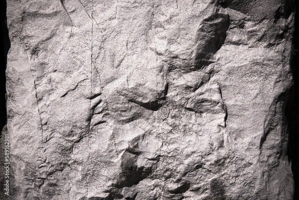 Fototapeta Stone texture of an old rough building wall with cracks, reliefs, plots. Random pattern