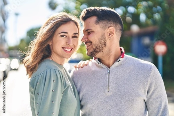 Fototapeta Man and woman smiling confident hugging each other standing at street