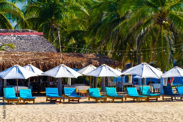 Fototapeta Palms parasols sun loungers beach people Zicatela Puerto Escondido Mexico.