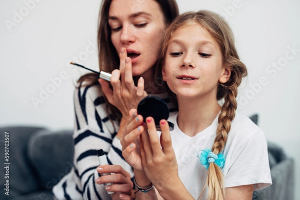 Fototapeta Mother and daughter do their own makeup