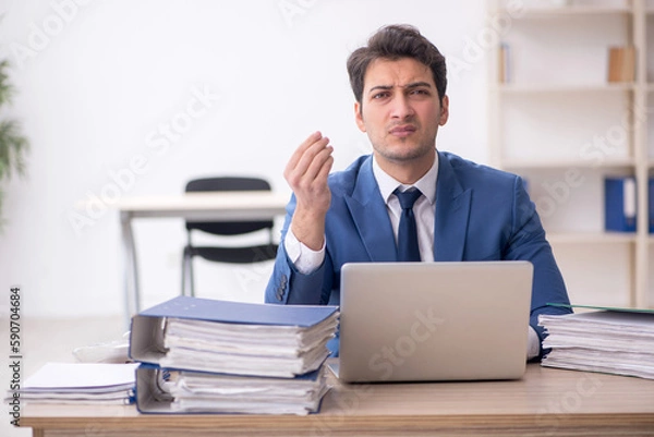 Fototapeta Young male employee and too much work in the office