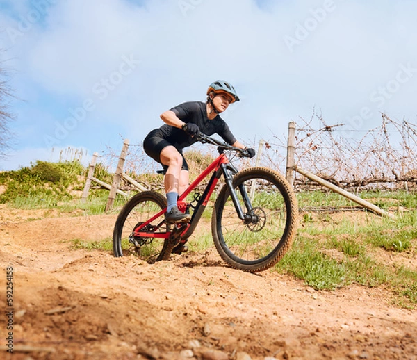 Fototapeta Bicycle fitness, countryside road and woman on a bike with speed for sports race on cycling path. Adventure, biker exercise and fast athlete doing training in nature on a trail for cardio and workout