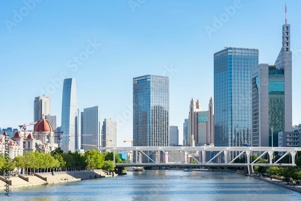 Fototapeta Beautiful shot of modern city skyline with a river view and blue sky