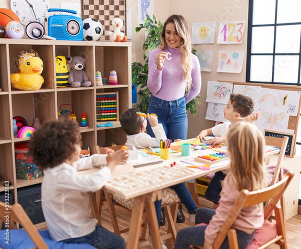 Fototapeta Woman and group of kids having vocabulary lesson at kindergarten