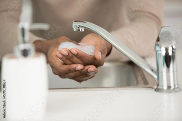 Fototapeta close view of soapy hands being washed