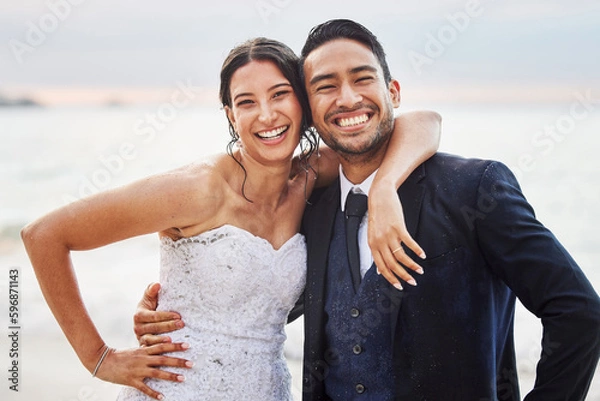 Fototapeta For better or worse, in sickness and health, for richer or poorer. Shot of a young couple on the beach on their wedding day.