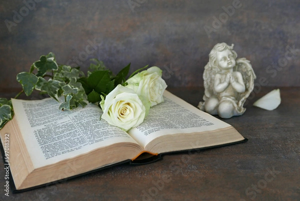 Fototapeta Religiöses Stillleben mit Bibel, Engel, weißen Rosen und Platz für Text.