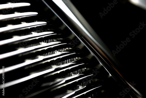 Fototapeta A closeup of a race car’s grille its chrome grill gleaming and racing stickers proudly visible Speed drive concept. AI generation. Generative AI