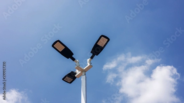 Fototapeta A modern street LED lighting pole. Urban electro-energy technologies. Poles on the road with LED light. Outdoor lighting strong LED lamp.