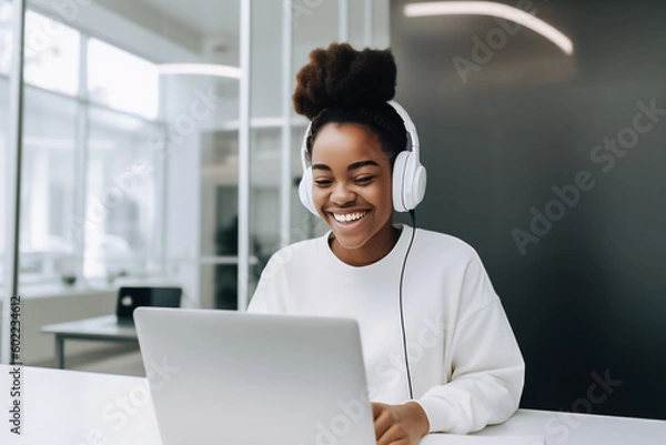 Fototapeta A confident black woman is hard at work on her laptop in a modern and bustling startup office, smiling with satisfaction at her progress. generative AI.