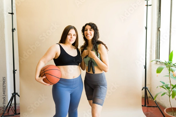 Fototapeta Plus size woman and latin friend playing basketball