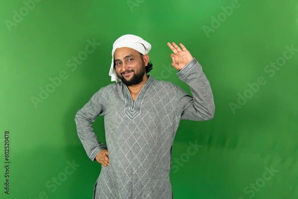 Fototapeta Young Indian farmer okay symbol on left hand with smiling and looking at camera, isolated on green background, green screen, copy space