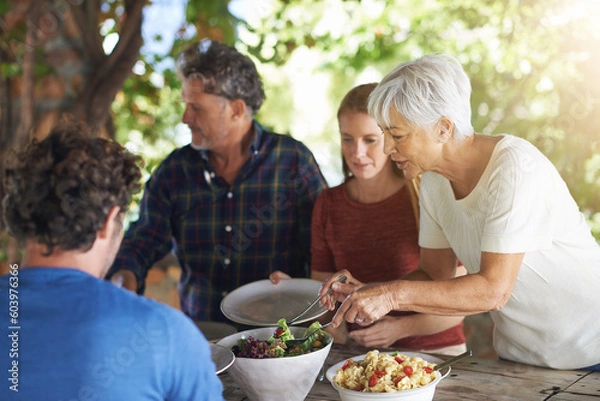 Fototapeta Food, party and salad with family at lunch and serving for health, bonding and celebration. Vacation, social and event with parents and children eating together for dining, generations and wellness