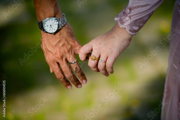 Fototapeta groom in pink suite hold hangs finger of bride.concept for wedding card background, poster,Invitation card