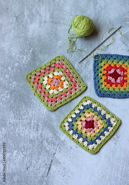 Obraz Colorful crochet Granny squares on light grey background with copy space. Handmade blanket in process. Multicolored vintage ornament. Hippie fashion concept. 