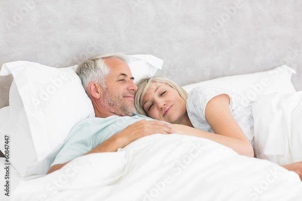 Fototapeta Loving mature man and woman lying in bed