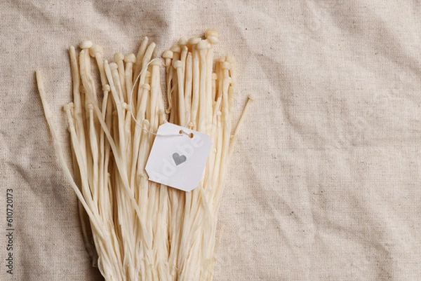 Fototapeta Natural medicine, reduce stress and improve immunity concept. Mushroom drink. Copy space. Tea bag on enoki mushrooms on grey textile background. 