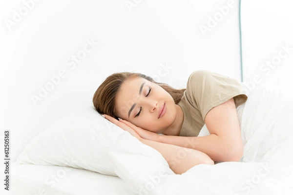 Fototapeta Healthy sleeping. Peaceful sleep of the carefree woman lying on white linen in bright bedroom.