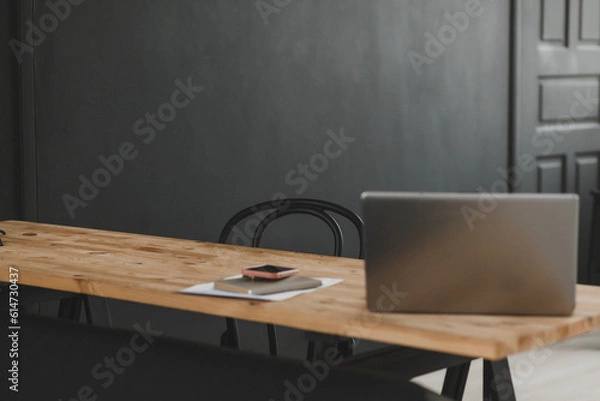 Fototapeta Administrator's workplace with a laptop against a dark wall. Interior Design