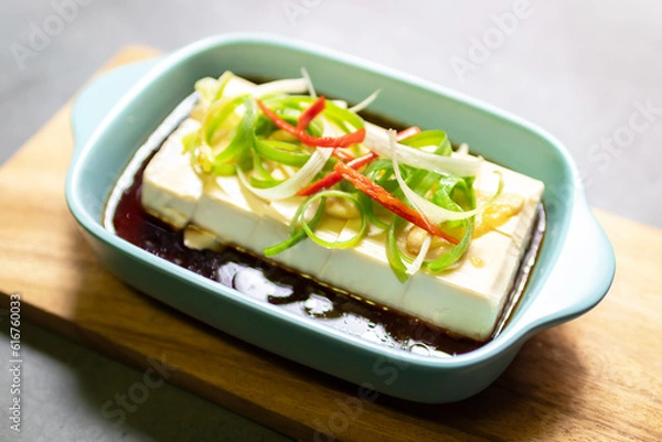 Fototapeta Vegan silken tofu is served hot or cold with a savory soy sauce flavored with sesame oil, ginger and green onions .