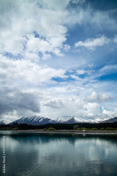 Obraz Pristine lake and snowy mountains against a blue sky.