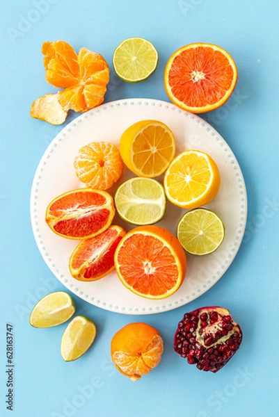 Fototapeta Layout of citrus fruits on white plate top view