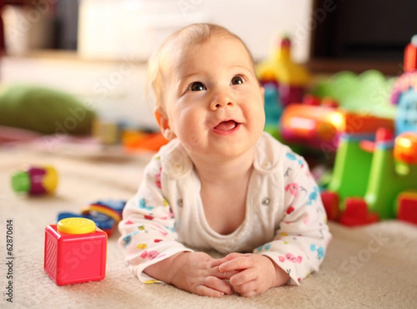 Fototapeta Cute smiling baby lying on floor