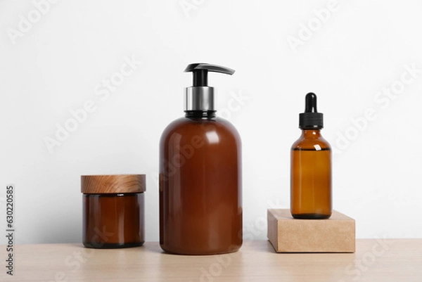 Fototapeta Bottles with different cosmetic products on wooden table