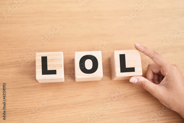 Fototapeta Woman hand holding cubes with lol word on the table