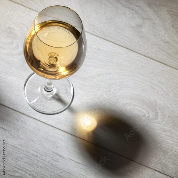 Fototapeta Glass of white wine on wooden table. Top view