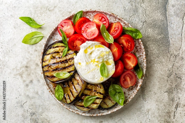 Fototapeta Plate with Burrata or mozzarella cheese and vegetables, grilled eggplant, tomatoes, basils, grissini and olive oil. Italian food, snack.