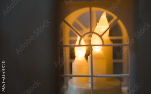 Fototapeta Artificial candles lit behind white framed windows. Candles inside hanging small transparent box for room or wedding party decor. Empty blank copy text space.