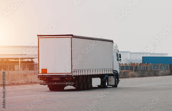 Obraz Truck isolated. Vehicle isolated. Commercial transport. Semitrailer during loading the cargo. Modern semi-trailer trucks on the highway. Commercial vehicle for shipping and post delivery.