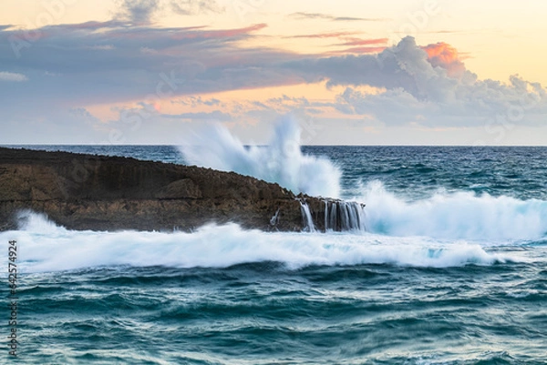 Fototapeta Wave breaking at sunset