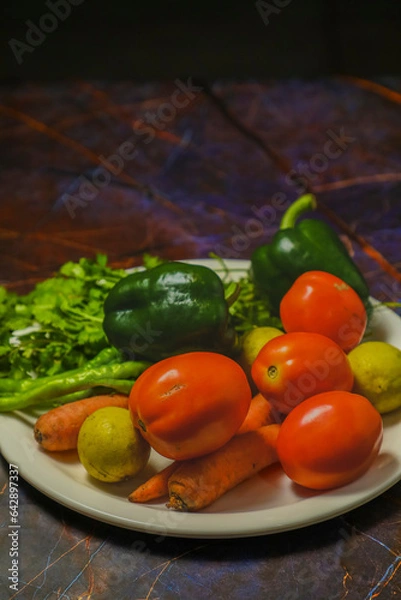 Fototapeta A white plate with pickled tomatoes, lemon, carrot and other vegetables