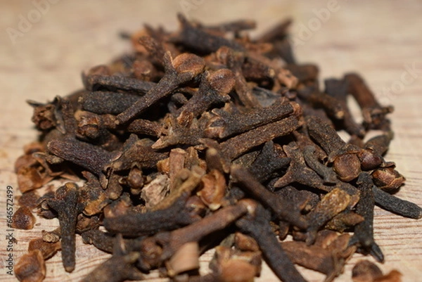 Fototapeta aromatic cloves close-up over a wooden table kitchen