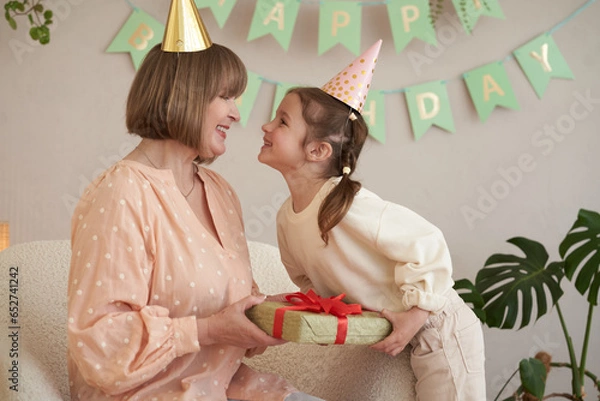 Fototapeta Family son his wife and granddaughter celebrate grandma birthday