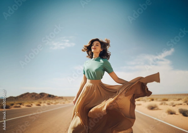 Fototapeta Beautiful brunette dressed in a retro dress from the 60s stands in the middle of nowhere in the middle of the road on a sunny day. Generative AI...