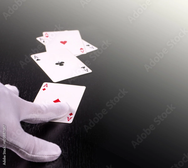 Fototapeta hand of the dealer in white gloves in a casino handing out cards