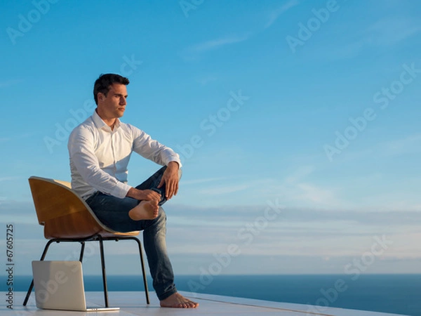 Fototapeta relaxed young man at home on balcony