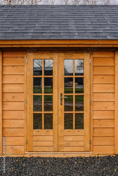 Fototapeta Massive wooden entrance doors with round handles and small keyhole close up. Double doors in solid wood in natural wooden color