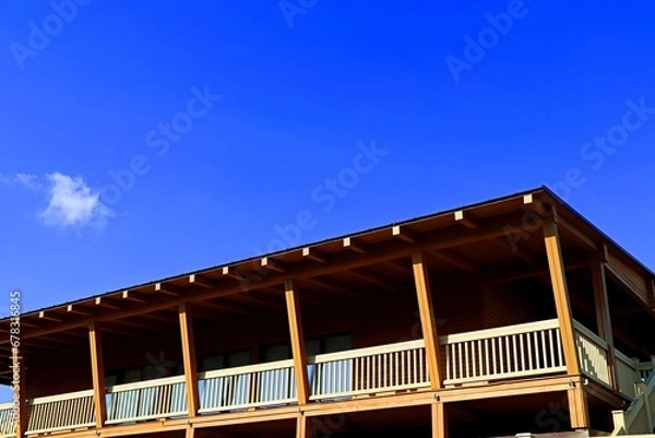 Fototapeta Wooden house made of pine beams with a covered veranda on the second floor