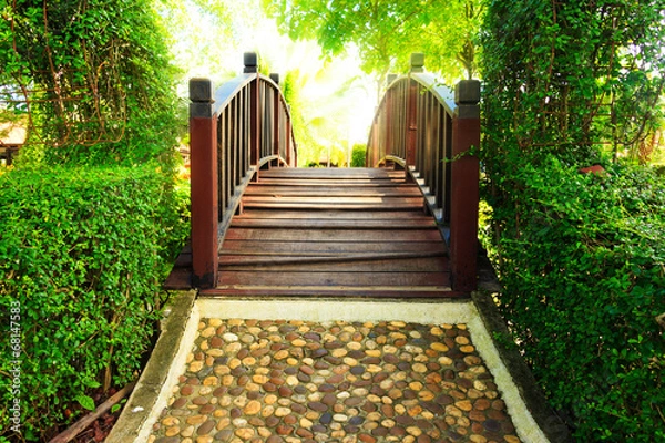 Fototapeta Wood bridge and Pathway in garden design with sun ray