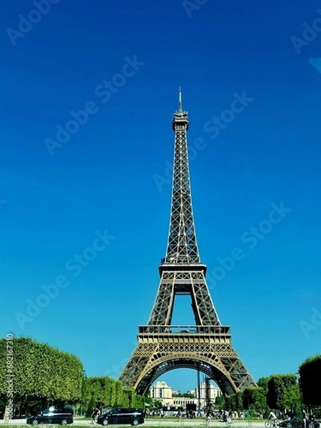 Fototapeta Scenic view of the Eiffel Tower in Paris, France, with a bright blue sky overhead