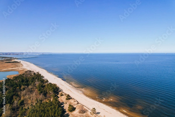 Fototapeta Aerial view drone of river goes into the sea. Delta of Vistula river goes in Baltic Sea in Sobieszewo Gdansk Poland. Forest and small village around river