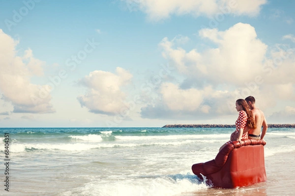 Fototapeta couple resting on leather couch on the beach