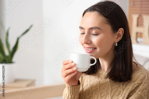 Fototapeta Pretty young woman drinking fresh coffee in living room, closeup