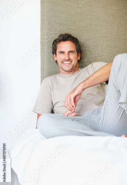 Fototapeta Portrait, happy or man relax in bed in the morning after nap, break or awake from comfortable sleep at home. Mature guy, smile or wake up in bedroom for healthy rest, routine or cozy day in apartment